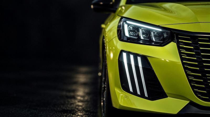 Les feux avant d'une Peugeot 208 jaune, de près